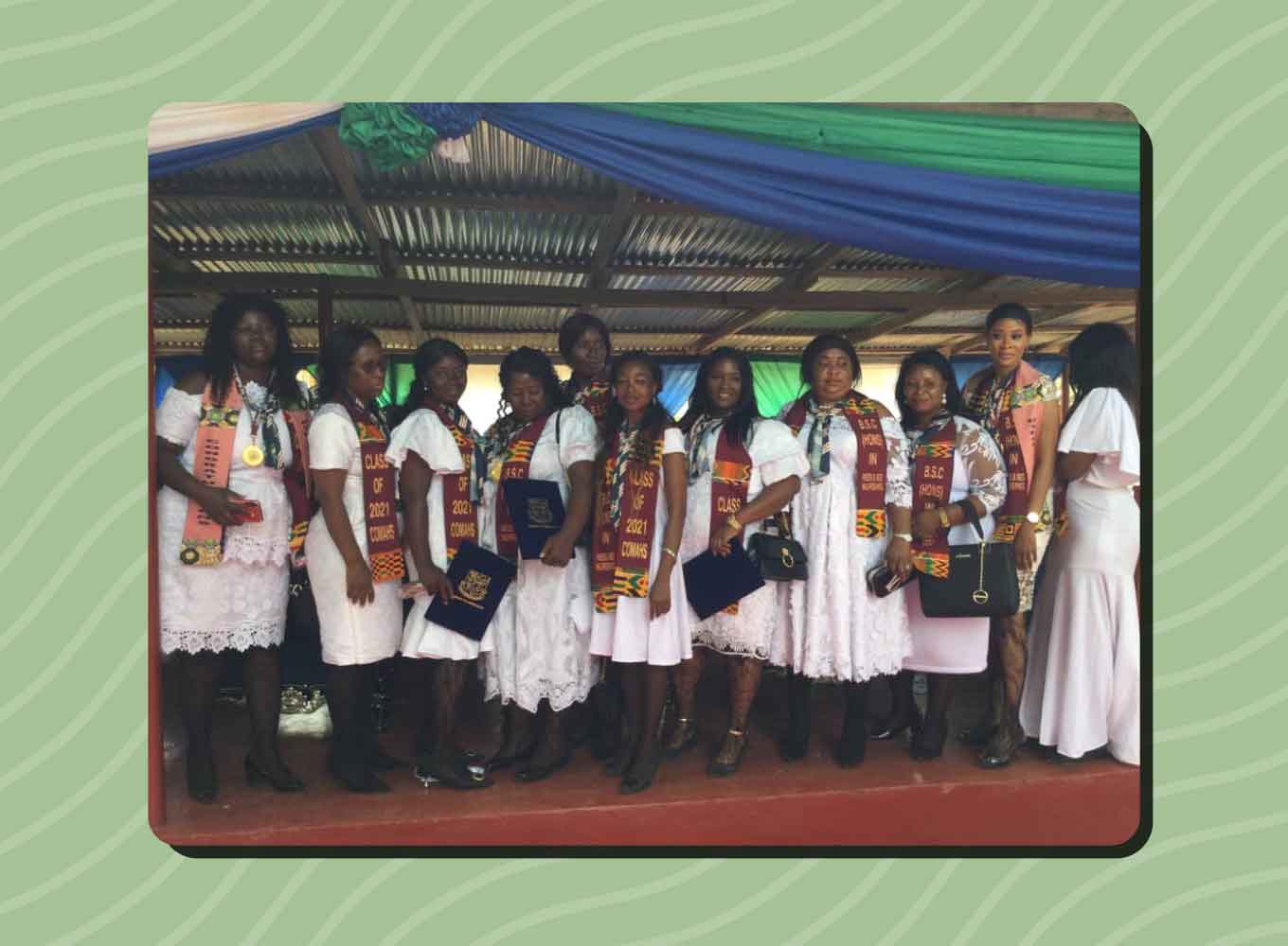 A group of Sierra Leonean neonatal nursing students wear graduation regalia and hold diplomas